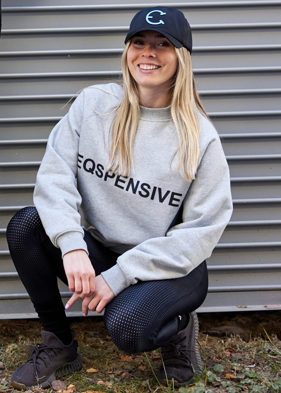 Person wearing a gray sweatshirt with the word 'EXPENSIVE' printed on it.