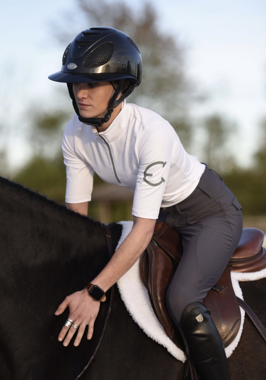 Person in equestrian gear preparing to ride a horse.