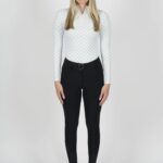 Woman in a white long-sleeve top and black pants posing against a plain background.