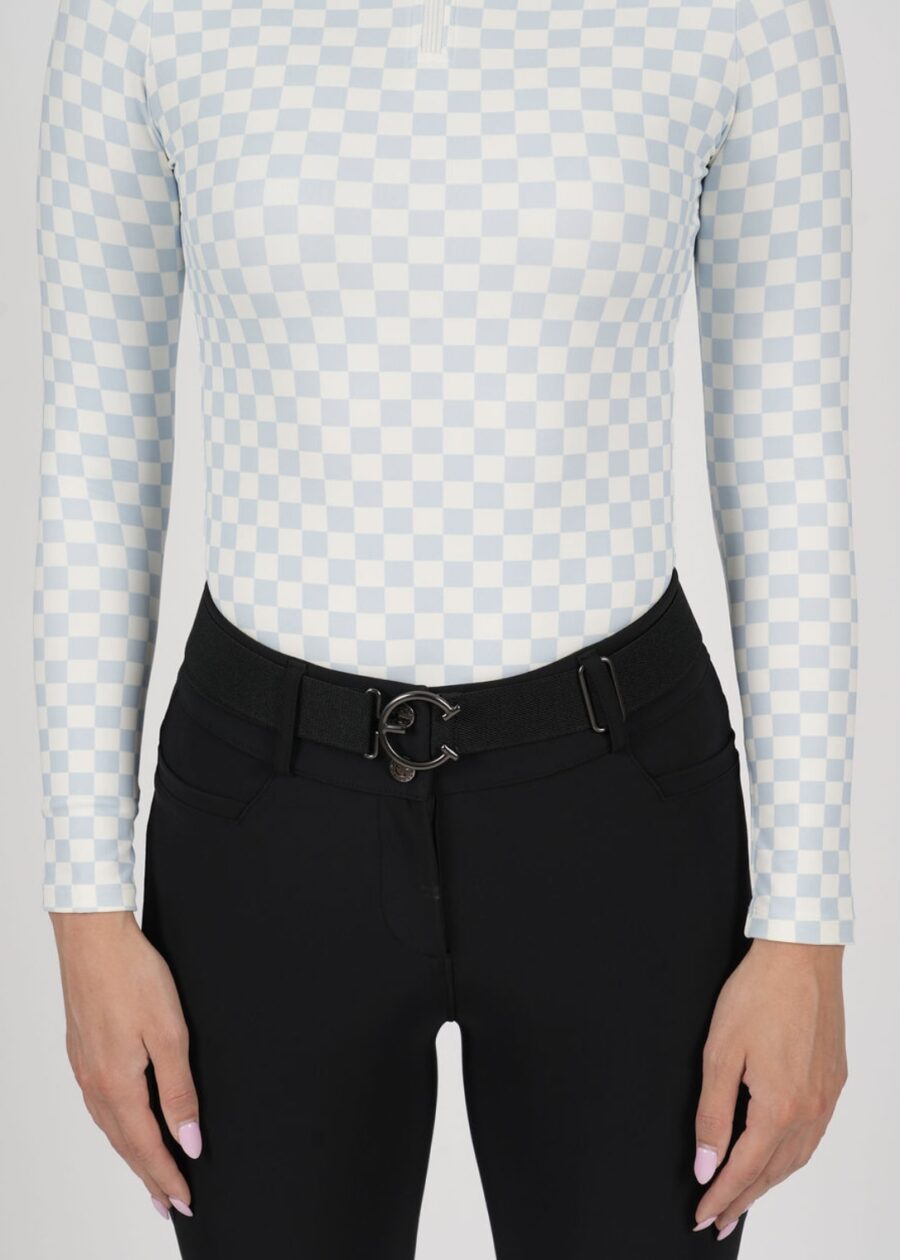 Close-up of a person wearing a white patterned top and black pants with a stylish belt.