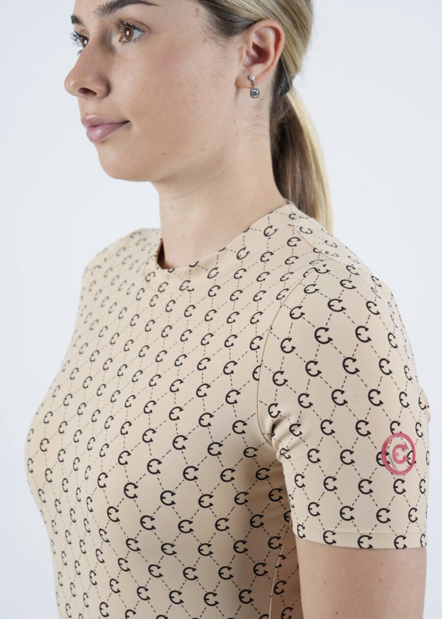 Woman wearing a beige sweater with a repeating crescent moon pattern.