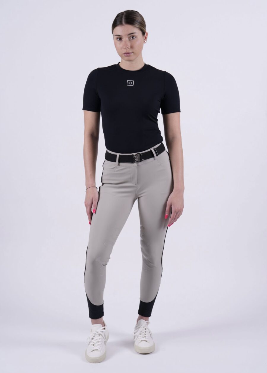 Person wearing beige riding pants and a black t-shirt.
