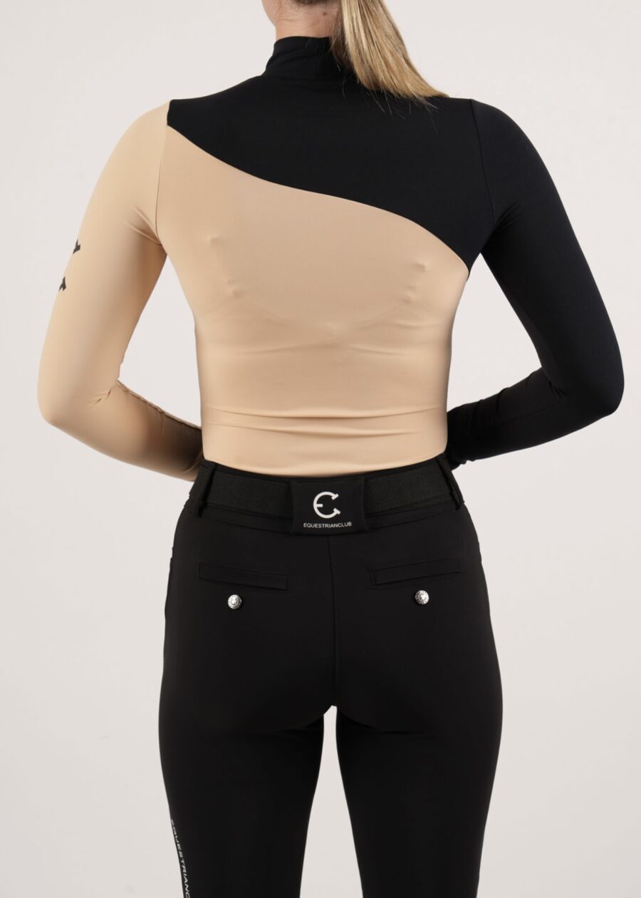Person wearing a unique asymmetrical one-shoulder top and black pants.