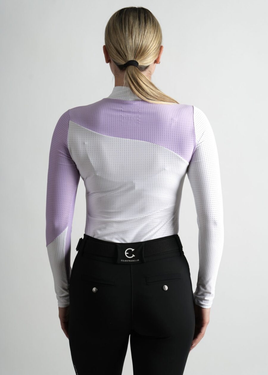 Woman wearing a white and lavender long-sleeve top and black pants.