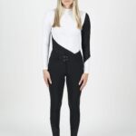 Woman wearing a stylish black and white asymmetrical outfit with leggings.