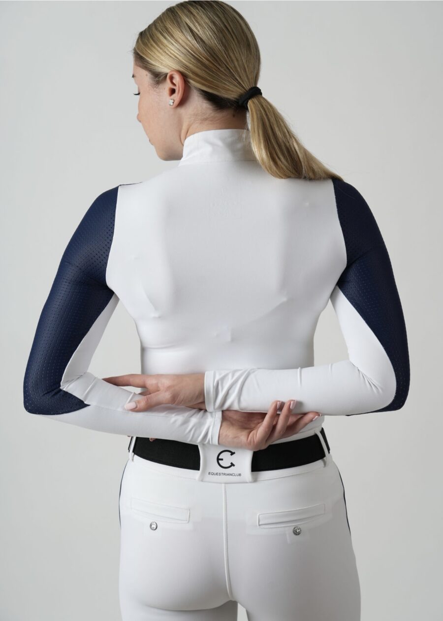 Person zipping up a white and navy jacket from behind.