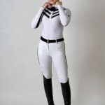 Person wearing a white and black equestrian outfit with riding boots.