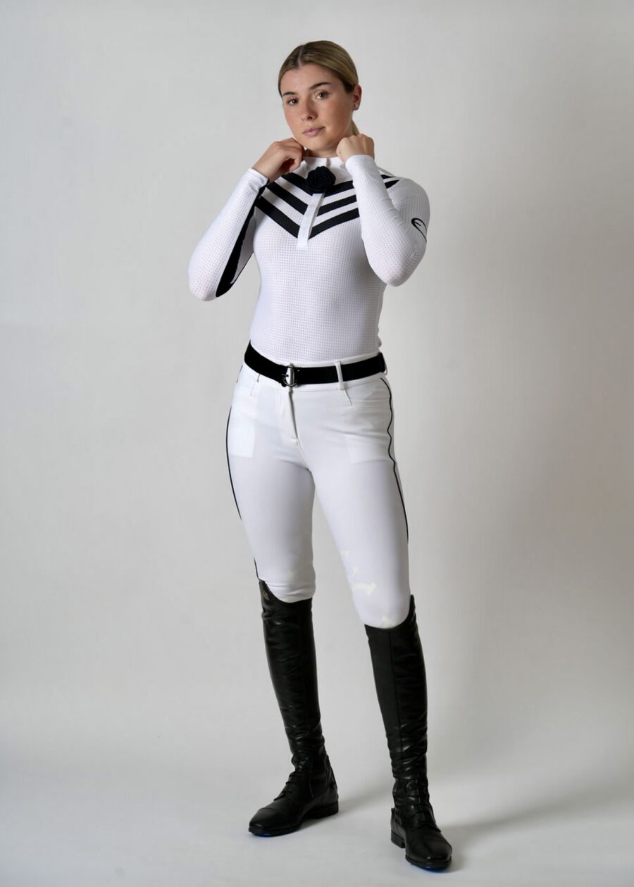 Person wearing a white and black equestrian outfit with riding boots.