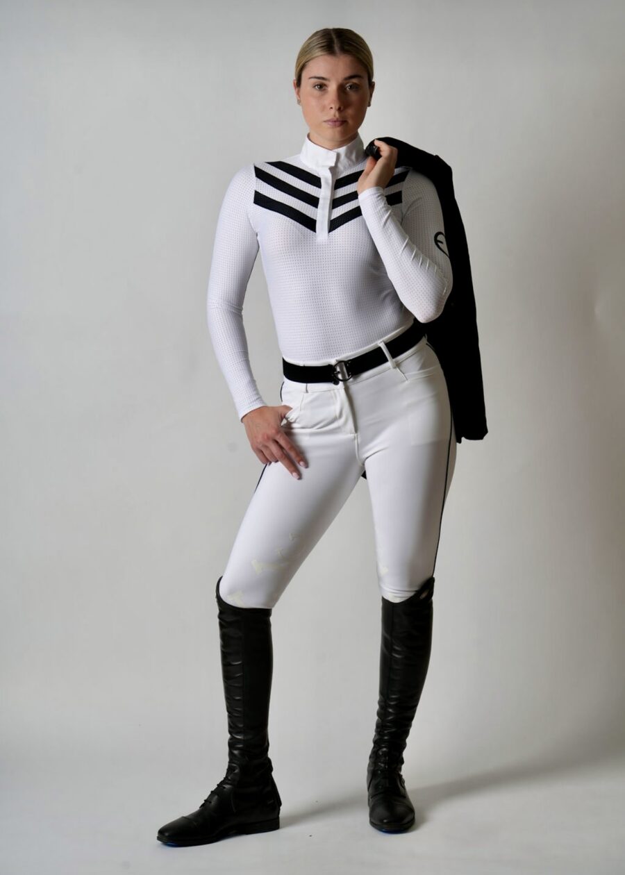 A person dressed in a stylish white equestrian outfit with black boots and jacket.